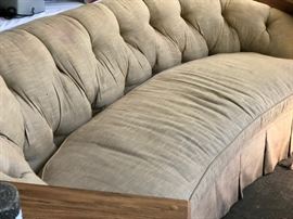 Tufted sofa with rounded arms and pleated dust skirt