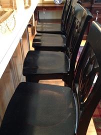 Four black bar stools