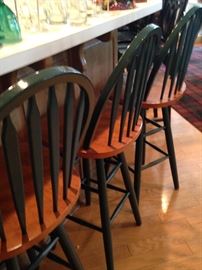 Four dark green bar stools