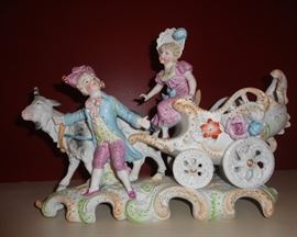 Antique bisque goat pulling cart with girl and boyfriend