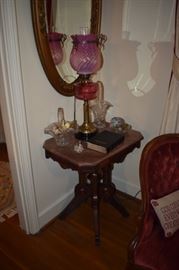 Beautiful Brass and Glass Antique Oil Lamp with Cranberry Glass Bowl and Cranberry Swirl Glass Shade with a fancy ornate metal band on Shade.  Also pictured are 2 Fenton Glass Baskets, a Gorgeous Highly Carved Victorian Marble Topped Table and Beautiful Ornate Oval Wall Mirror