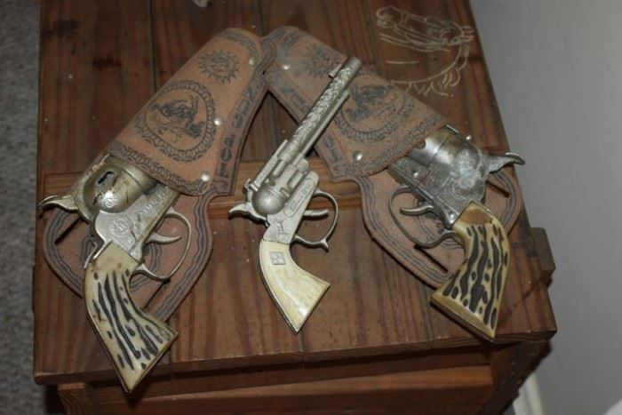 In "Top Gun" Holsters are Twin Mattel, Inc. Toymakers "Fanner" Cap Gun Pistols also pictured is a "Young Buffalo Bill" Cap Gun with an "H" inside the Diamond Shape on the Pistol Grip all in Great Condition!