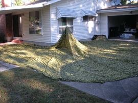 We took the round green camouflage parachute canopy outside to check its size. We wanted to spread it out on the grass but it was early in the morning and the grass was too wet, so we opened it (as much as  we could) on the driveway. It is huge!!!!  It is a CARGO parachute.  Without pulling it tight to keep it off of the grass, we measured it to be about 40 feet in diameter.  There are tie downs  around it and a designed hole in the middle (photo coming up).  My client believes her father used this cargo chute in the early 1960's when landing the instrumentation from the balloons that were launched in the projects he worked on for the U.S. Air Force.   
