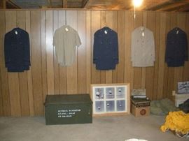 Basement:  Five military uniforms hang above a metal foot locker, a series of aviation photos (closer photo coming up), and a yellow 1950's parachute.  