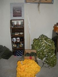 Basement:  Various military theme items are on the shelving rack beneath a photo of jet fighters.  When my client's father retired, his team members signed the photo so there are numerous autographs on the mat frame.  Also shown are two parachute canopies.  Closer photos are coming up of those real soon.