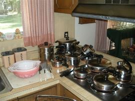 Kitchen:  Two vintage pink/plastic canisters are behind a set of vintage pink & white "Gooseberry/Cinderella" pattern 4-piece PYREX nesting bowls.  To the right is a very nice selection of vintage REVERE copper bottom cookware (each piece is priced individually).  