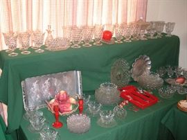Kitchen:  Yes, more FOSTORIA AMERICAN:  5-l/2" stems; 6" iced tea glasses; 4" sherbets; 9-l/2" dinner plates; 8" salad plates; 6" dessert plates; cups & saucers; bowls; platters; covered footed square "wedding" compote; divided dishes; olive dish; sugar & creamer; and an oil cruet with stopper.  Also shown are red wood candleholders; ceramic apples; vintage flatware in a red caddy and some hand forged aluminum.