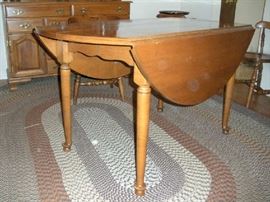 Dining Room:  This beautiful drop-leaf maple table measures 28" x 54" with the leaves down.  However, with the leaves up, it measures 54" round.  Two 9" leaves are also included which will convert the table to an oval shape.  It is priced separately from the six maple chairs.  The oval braid rug measures 11'  4"  x  8'  8."