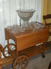 Dining Room:  A maple tea cart (SPRAGUE & CARLETON) with drop leaves displays a FOSTORIA AMERICAN 14" diameter punch bowl with separate pedestal, plastic ladle, and ten punch cups. The FOSTORIA punch bowl set is priced as one unit.  