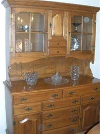 Dining Room:  The two-piece SPRAGUE & CARLETON maple hutch has two upper glass doors, one middle door, and two small drawers while the lower section has a total of six drawers and one door on each side.  It has lots of storage!  The manufacturer is SPRAGUE & CARLETON; it measures 55" wide x 21" deep x 76" tall.  Displayed on the hutch are several pieces of vintage FOSTORIA AMERICAN:  a 6" tall ice jug; an 8" tall lipped ice jug; a 5" nappy and cover; and a 14" torte plate.  There is a huge collection of more FOSTORIA AMERICAN in the kitchen.  Inside the hutch are various pieces of silver-plate.
