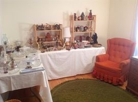 Bedroom #4:  Glass, brass and Asian items are displayed on the tables next to the orange swivel/rocker chair.  The vintage green oval rug is also for sale.  