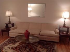 Living Room:  The mid-century modern champagne color sofa is by AMERICAN FURNITURE CO., El Paso, TX, and is 8' 4" long.  It has three removable seat cushions, three attached back cushions, and is on brass casters.  The heavy brass lamps are sold as a pair as are the like-new vintage mahogany/leather top step-back side tables.  The frameless vintage mirror above the sofa measures 40" X 30."  The mid-century heavy brass engraved oval tray rests on a teak wood stand and is removable (a closer photo follows).  