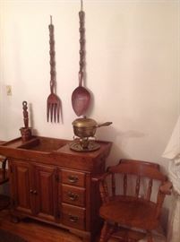 Dining Room: This SPRAGUE &  CARLETON dry sink has a copper liner, two doors and three front drawers.  A smaller lift-up drawer is to the left of the copper sink, and a small drawer is on the right side of the dry sink.  The vintage wooden fork/knife set has carved head handles and pairs well with the carved wood head ladle on the dry sink.  The arm chair shown is part of the 6-chair set (2 arm chairs + four side chairs).  The brass chafing dish is also for sale.  