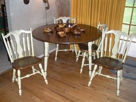 Family Room: A creamy white/gold stenciled table and four chairs are priced as a set. Displayed on top of the table is a monkey pod salad set. 