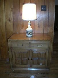 Family Room:  A two-drawer/two door cabinet displays a vintage ceramic lamp.
