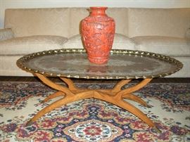 Living Room:  Now you can better see the large oval brass tray that rests on a teak wood stand with tapered legs and brass caps.  The red vase is ceramic but looks like cinnabar. 