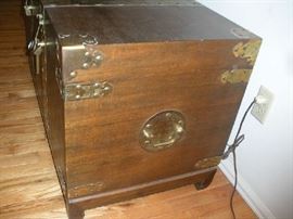 Living Room: This is a side view of the brass trim trunk. Although difficult to see, the brass has design work on it. 