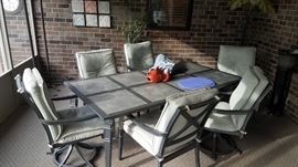 Slate top metal patio table with six swivel chairs