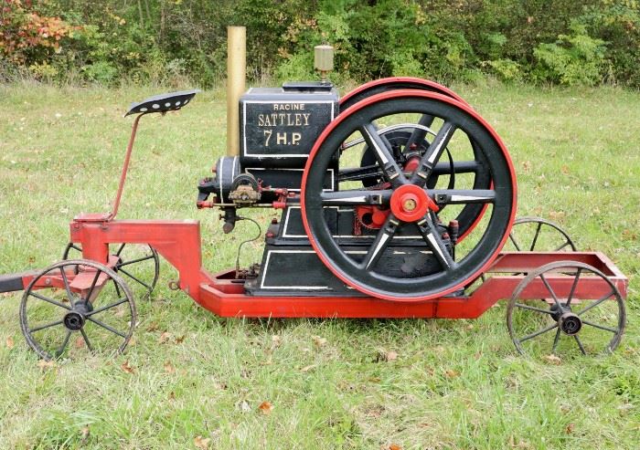 A Racine Sattley Hit and Miss Engine.  Marked "The Racine Sattley, Montgomery Ward & Co., New York, Chicago, Kansas City, Fort Worth Portland No. 13764 H.P. 7 Speed 375", on a later iron cart.  Restored and repainted with some wear.  59 1/2" h  x 113" long. 