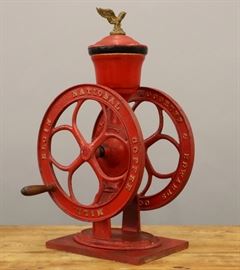 A late 19th century Woodruff & Edwards Co. Coffee Grinder.  Painted cast iron coffee mill, turned wood handle; marked "Woodruff & Edwards Co. Elgin, Ill." and "Elgin National Coffee Mill".  Wear and losses to the paint, some areas appear to have been repainted (the hopper, etc.), the spokes on one wheel are cracked.  27 1/2" high.