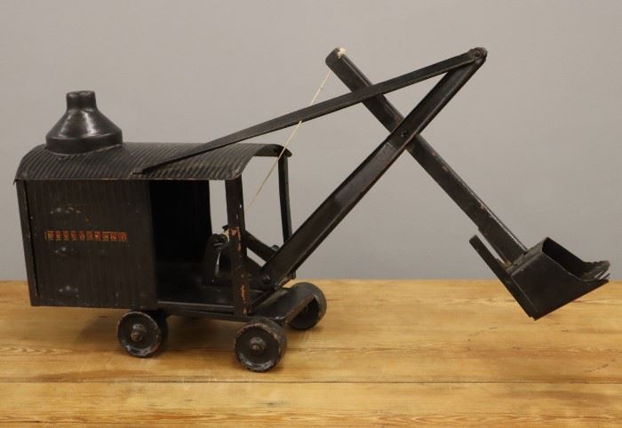 A Buddy L Pressed Steel Steam Shovel.  Black painted finish with decals on the sides.  Wear/losses to the paint.  19" long. 