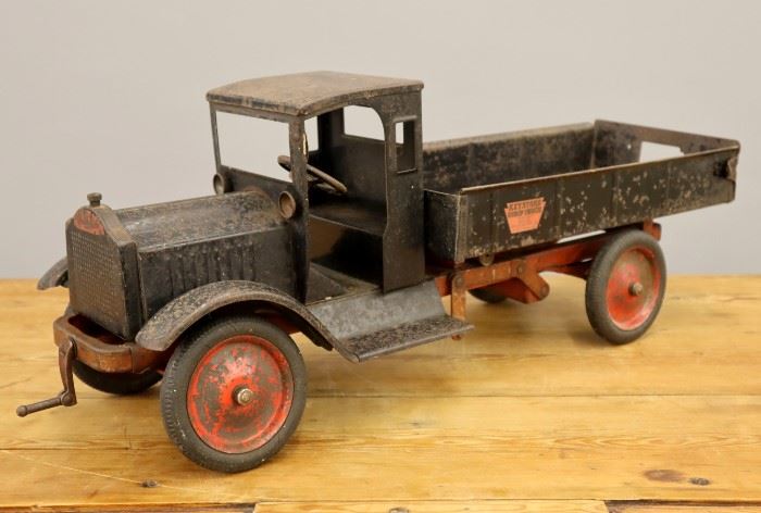 A 1920s Keystone Pressed Steel Toy Dump Truck.  Black painted finish with red accents, operating dump bed with tailgate and chute door.  Original decals include one at the front that reads "Keystone Packard Pat. Dec. 15 1925 Made in Boston".  Significant wear, corrosion.  27 1/2" long.  