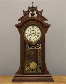 A late 19th century New Haven "Lena" model shelf clock.  8-day spring driven time and strike movement with a painted metal dial.  Walnut case with a pediment top and single long door with original reverse painted glass.  Older refinishing with wear and minor damage, some flaking to paint, pendulum rod repaired.  Running when cataloged.  36 3/4" high overall. 