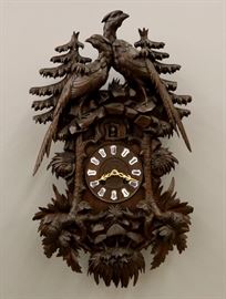 A 19th century Black Forest Cuckoo clock attributed to the Philip Haas Clock Co, St. Georgen, Germany.  Brass 14-day spring driven time and strike movement with gong and cuckoo.  Walnut case with hand carved Pheasants, porcelain dial numerals and carved bezel.  Partial paper label on back.  Old dark finish with some wear, minor loss to the carving.  Running when cataloged.  33" high overall.