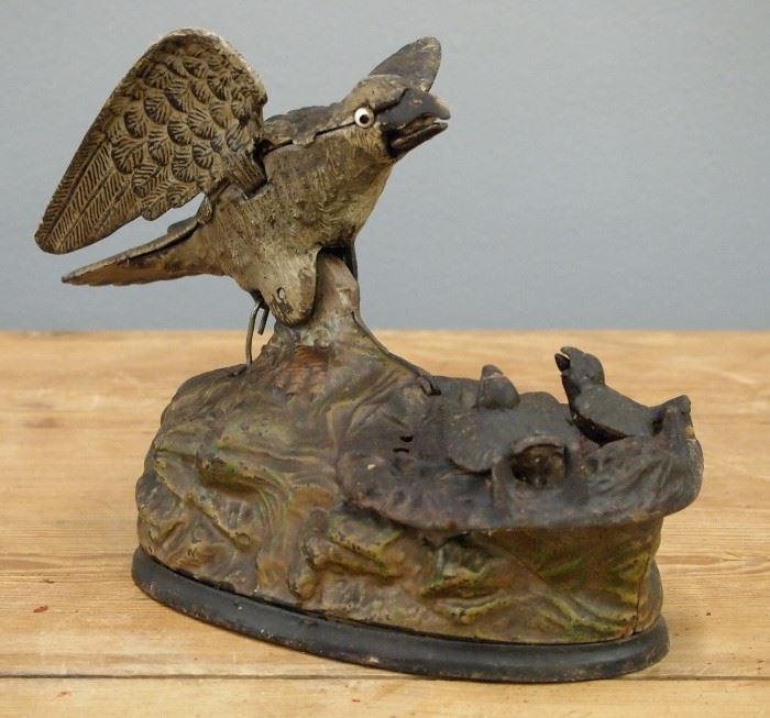 A 19th century Cast Iron "Eagle and Eaglets" Mechanical Bank.  Wear and significant paint loss.  6" high.