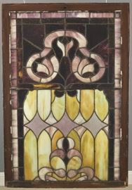 A late 19th century Stained Glass Window.  Multi color glass with a scroll work detail in a wood frame.  Some cracked panels, glass pane added to the exterior side.  34 x 49 3/4" high. 