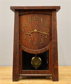 A turn of the century American Arts & Crafts Period shelf clock.  8-day time and strike movement with Brass hands and Arabic numerals.  Oak case with simple tapered pilasters.  Old dark finish with minor wear.  Running when cataloged.  20" high.