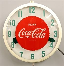 A mid 20th century Coca-Cola Advertising Clock.  Round, electric clock reads "Drink Coca-Cola" on the dial.  Clock runs and lights up, some wear, metal frame re-painted white.  22 1/2" diameter. 