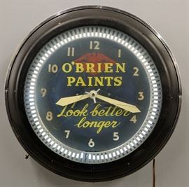 A mid 20th century O'Brien Paints Advertising Clock.  Round, electric clock reads "O'Brien Paints Look Better Longer" on the dial, with a metal frame.  Clock runs and lights up, some wear.  22 1/4" diameter.
