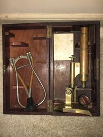 Antique doctor’s microscope and stethoscope set in original box.