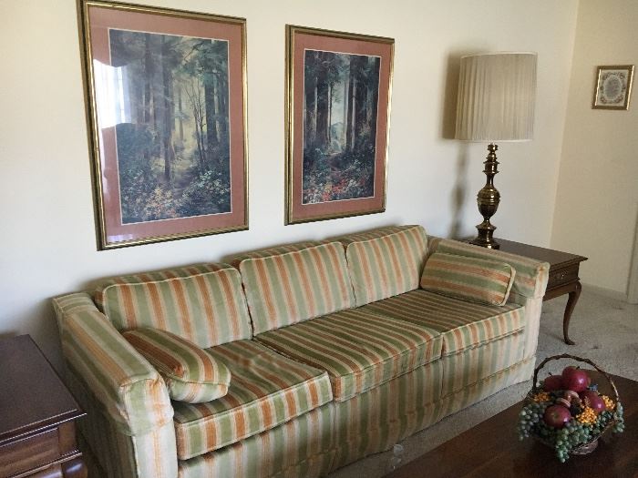 Traditional vintage striped velvet , sofa, cherry end tables, tall brass lamps and wall decor.