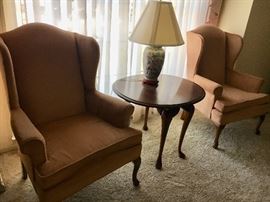 Pair peach color velvet Queen Anne chairs, round cherry drop-leaf table and Asian-theme lamp.