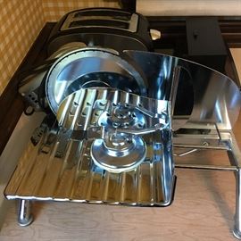 Assorted kitchenware—glasses, dishes, pots and pans, small appliances, stainless steel flatware, slicer and more.