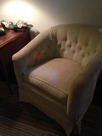 Curved back bedroom chair accented by deep button tufting