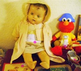 SLEEPY EYE DOLL WITH TIN EYES, EYELASHESS AND TEETH AND A HOME MADE OUTFIT THAT INCLUDES A LITTLE MUFF.  DON'T OVERLOOK ELMO WITH 3 HATS