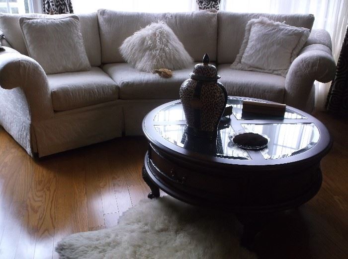 White curved sofa and round glass top display coffee table