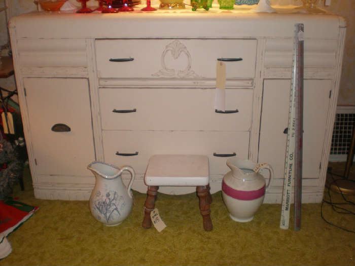 Large pitchers, stool, painted buffet, metal yardsticks.