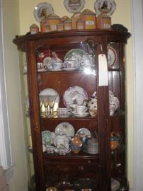 Deep china cabinet, luster canister set, cups and saucers, plates, teapots. 