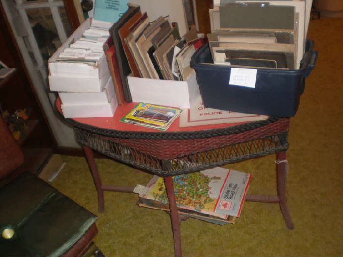 Wicker oval table, post cards, photos, atlases.