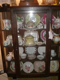 China cabinet full of german china and milkglass plates.