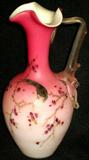 Lot #20: Hand Blown Art Glass Ewer, Dark To Pale Pink On Milk Glass, Painted Black & Gold Tone Bird Perched On Delicate Blossoming Branches, Applied Free Form Translucent Handle, Pontil On Underside, 8.25"T.