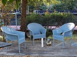Three powder blue stackable wicker chairs