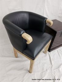 Barrel back club chair with black upholstery and carved arms.
Mahogany-stained lift-top storage box.