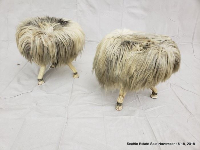 Long-haired round footstool with tri-footed animal-form legs and hoofed feet.