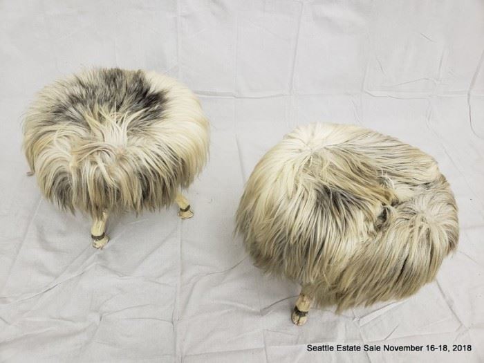 Long-haired round footstool with tri-footed animal-form legs and hoofed feet.