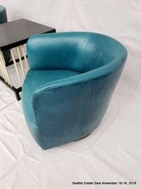Teal barrel-back club chair.
Square-top side table with turned spindle supports